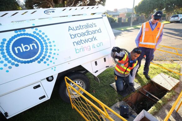 NBN Co service technicians working on Australia's broadband network infrastructure, with a service vehicle and open access point visible.