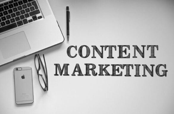 Laptop, glasses, and smartphone with the text "CONTENT MARKETING" emphasizing digital marketing strategies in the context of content syndication and B2B marketing.