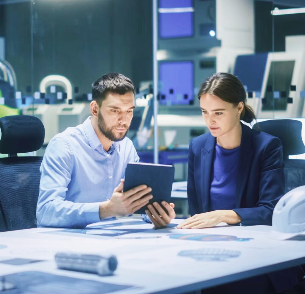 Two professionals reviewing content on a tablet at a modern workspace, emphasizing collaboration and B2B content strategy.