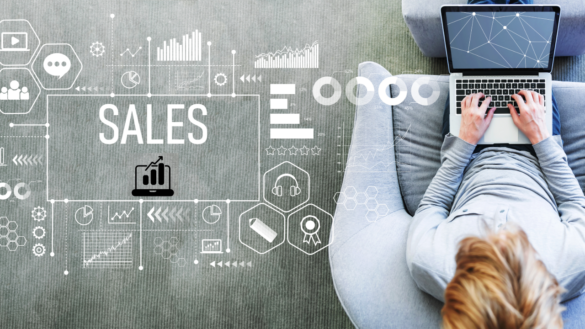 A Person Working On A Laptop While Sitting On A Couch, With Digital Sales And Data Analytics Graphics Overlaid On The Image.